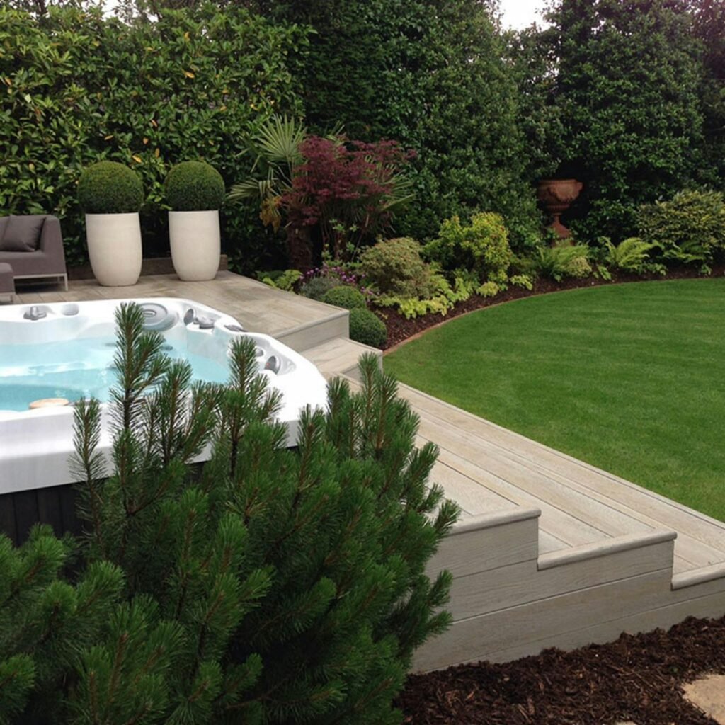 Backyard spa set into a deck in a landscaped garden