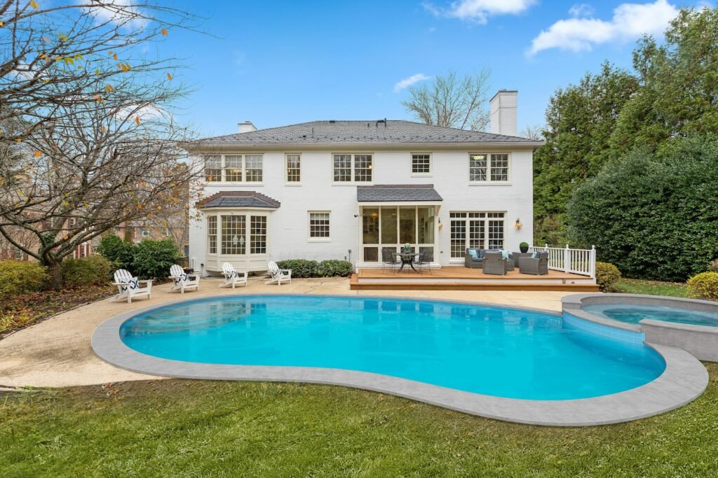 Classic two-story home with a curved backyard pool and lawn