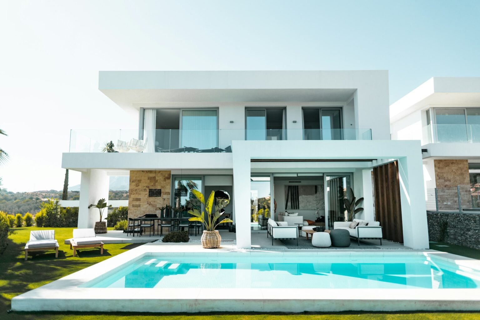 Modern residential swimming pool beside a white contemporary home