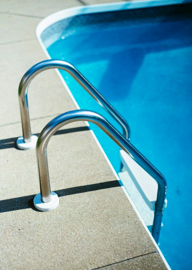 Stainless pool ladder over clear blue water