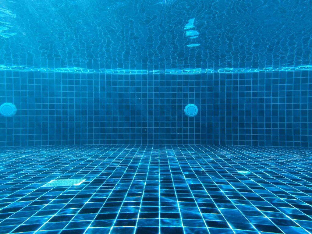 Underwater view of a blue tiled pool floor